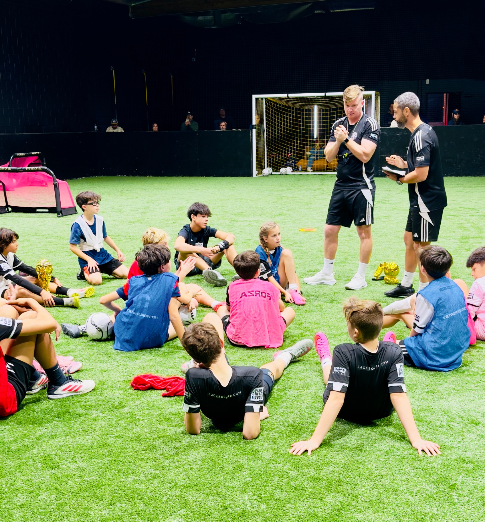Coaches running a youth training session on the indoor field